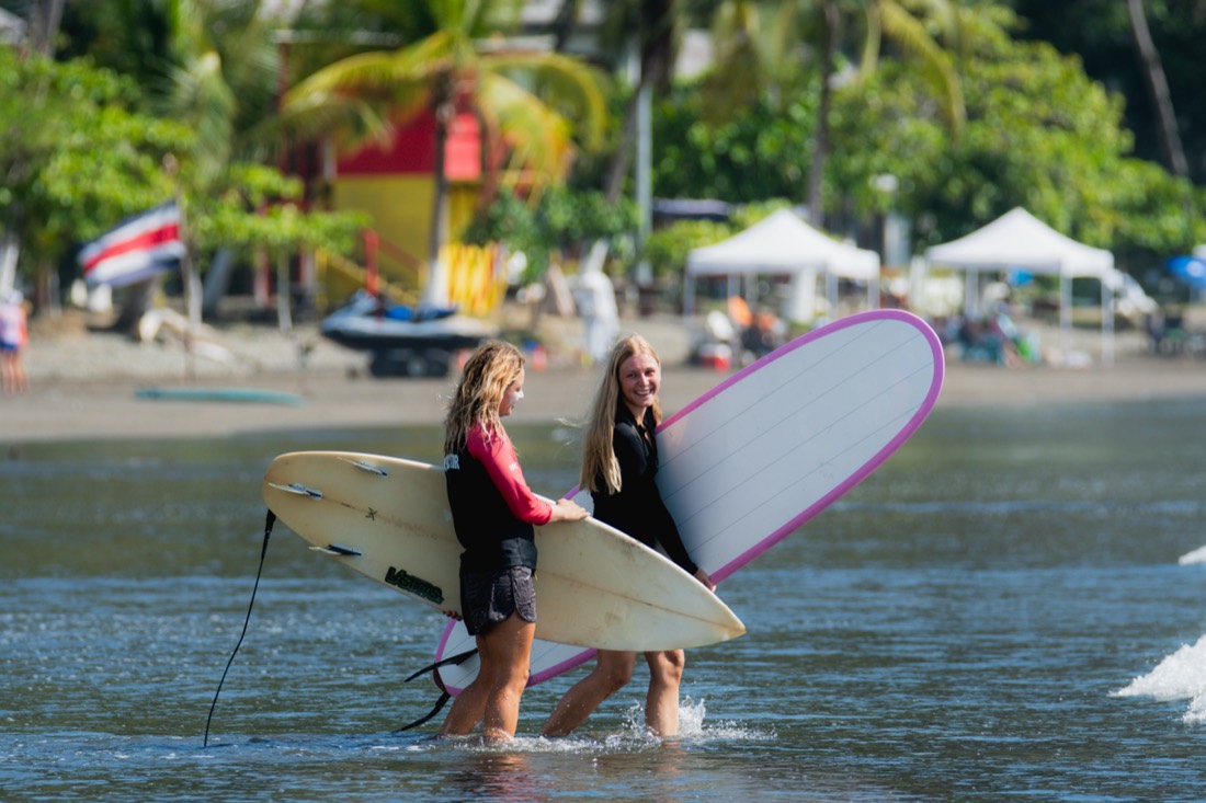 Students carrying surfboards to the water