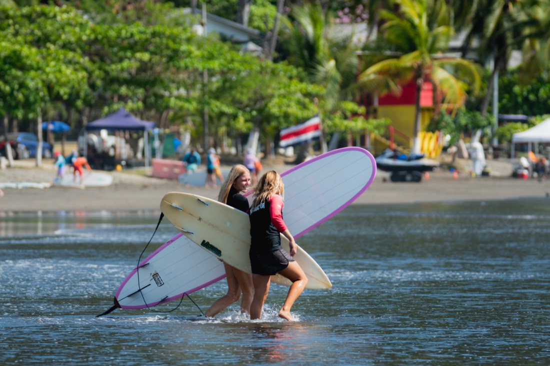 Walking into the surf with longboards